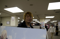 立ちPOPに囲まれるおちゃめな八木沼さん
